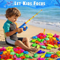 Child playing with kids fishing toy pole and colorful sea animal toys during outdoor water play